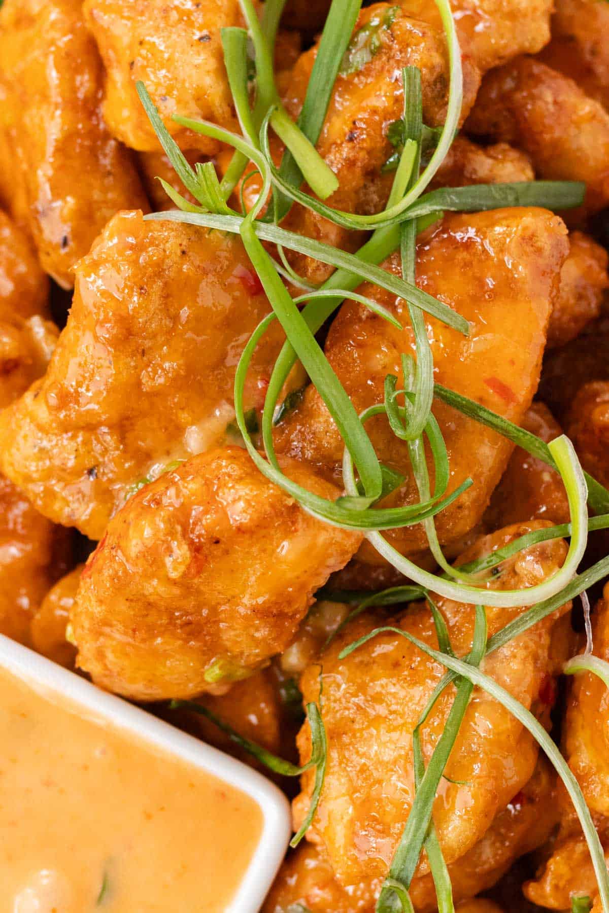 A close up of crispy bang bang chicken pieces in a pile.