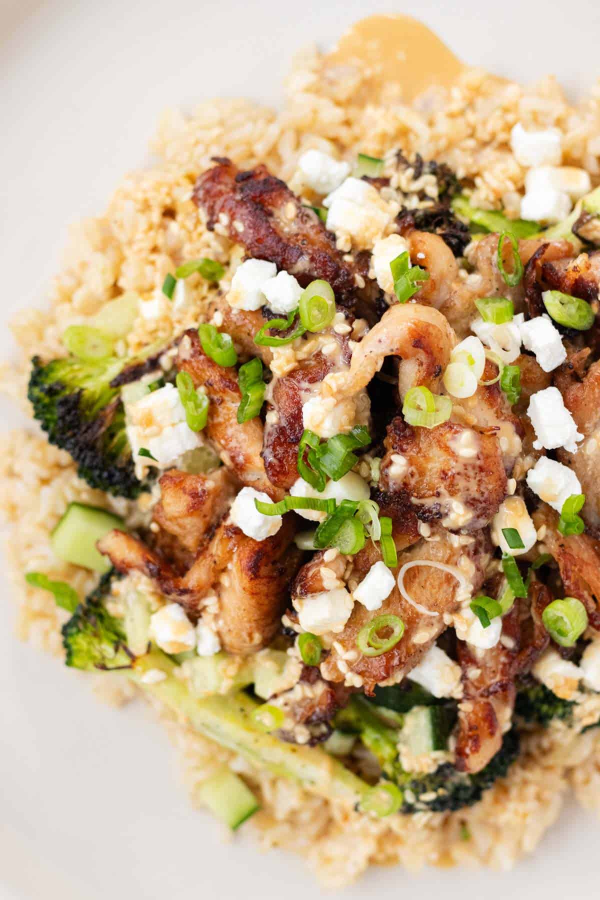 Chicken rice bowls piled with roasted broccoli, chicken, sesame sauce and goat cheese.