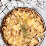 A large enamelled cast iron sauté pan filled with french onion soup pasta.