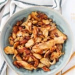 A blue bowl filled with velvet chicken with a pair of chopsticks on the side.