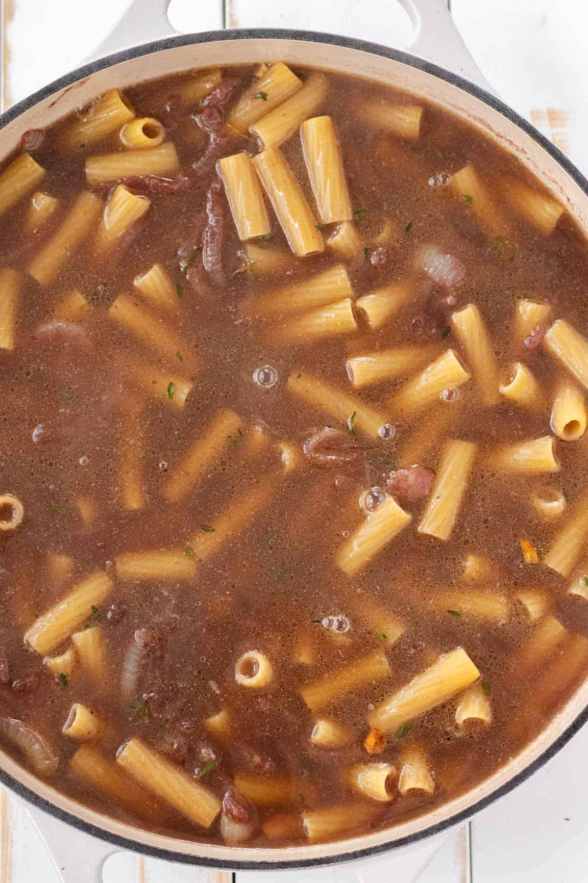 Adding the broth and noodles.