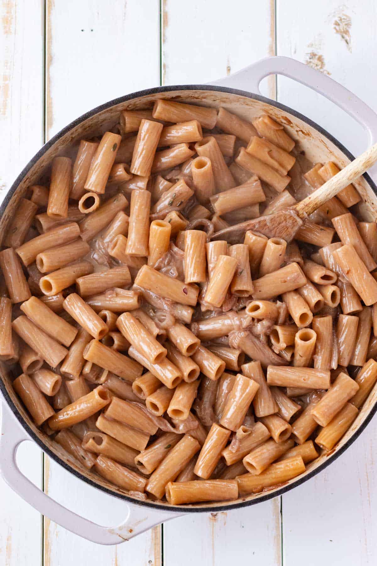 Stirring the coconut cream into the cooked pasta.
