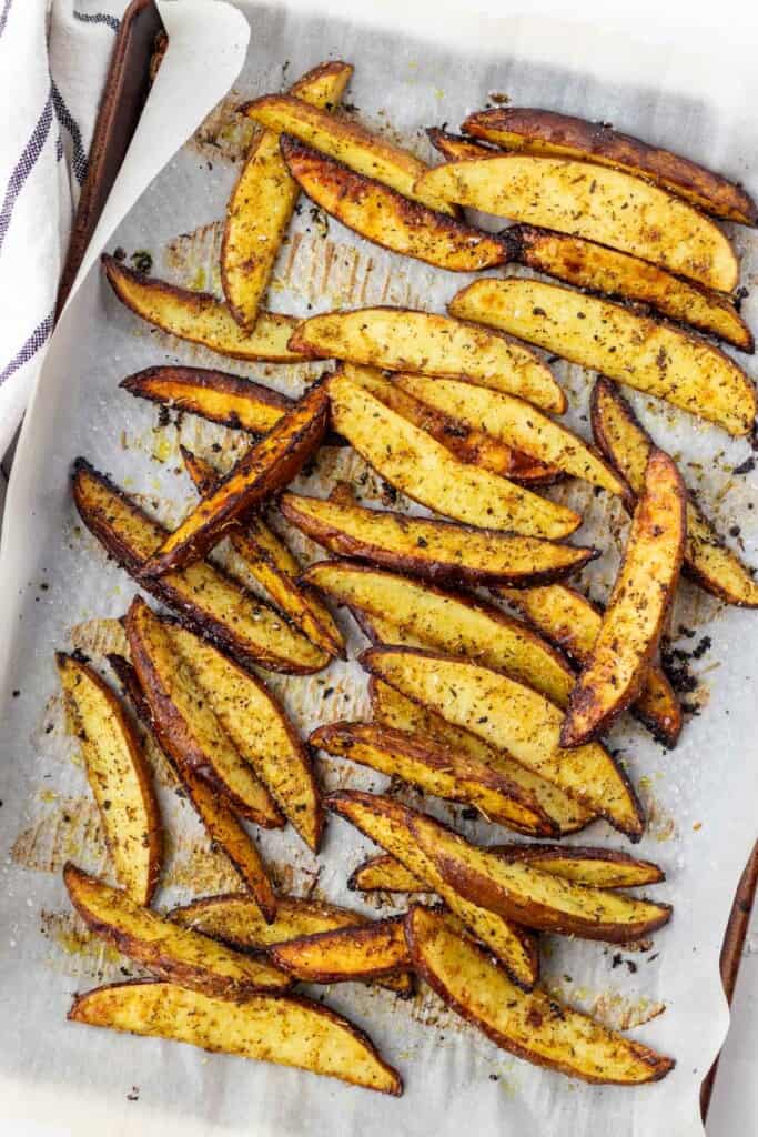Baked potato wedges on a sheet pan.