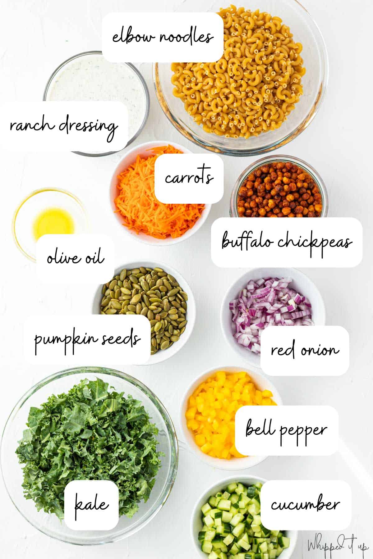 Ingredients include elbow noodles, ranch dressing, buffalo chickpeas, carrots, olive oil, pumpkin seeds, red onions, bell pepper, kale, and cucumber.
