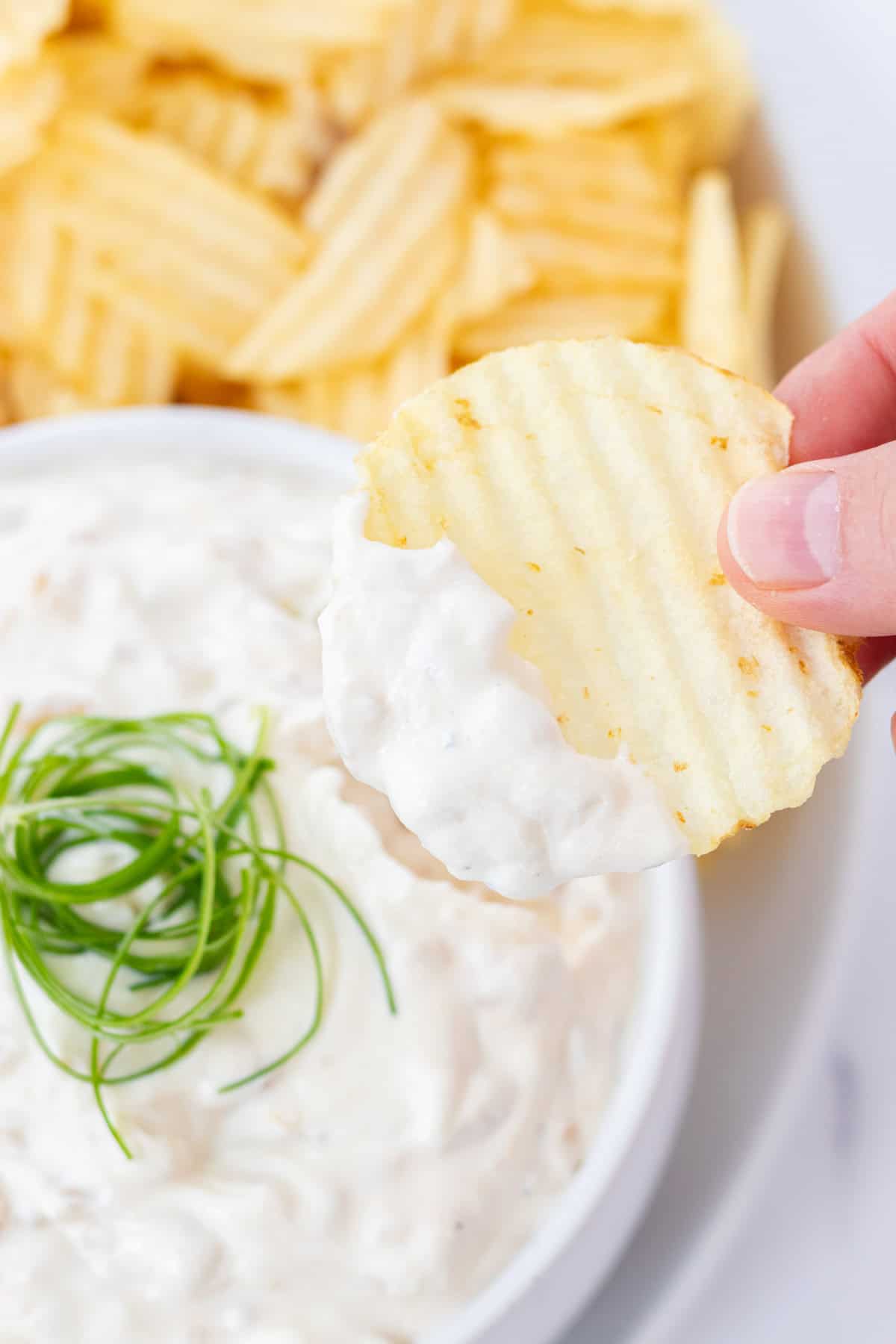 Dipping a chip into the onion dip.