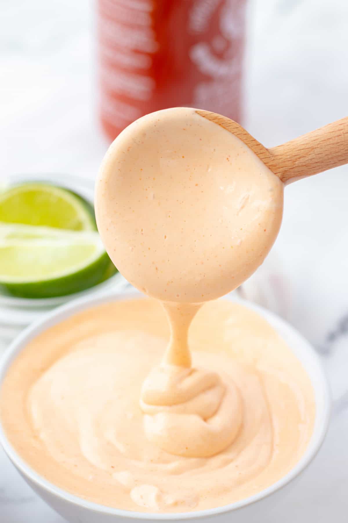 Homemade spicy mayo running off of a spoon.