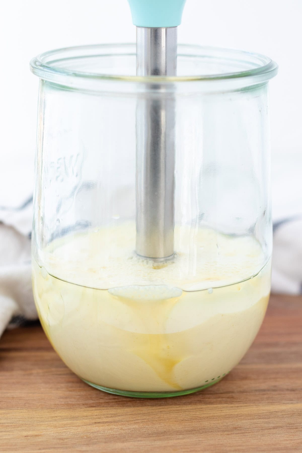 Slowly moving the immersion blender up as the mayonnaise starts to emulsify.