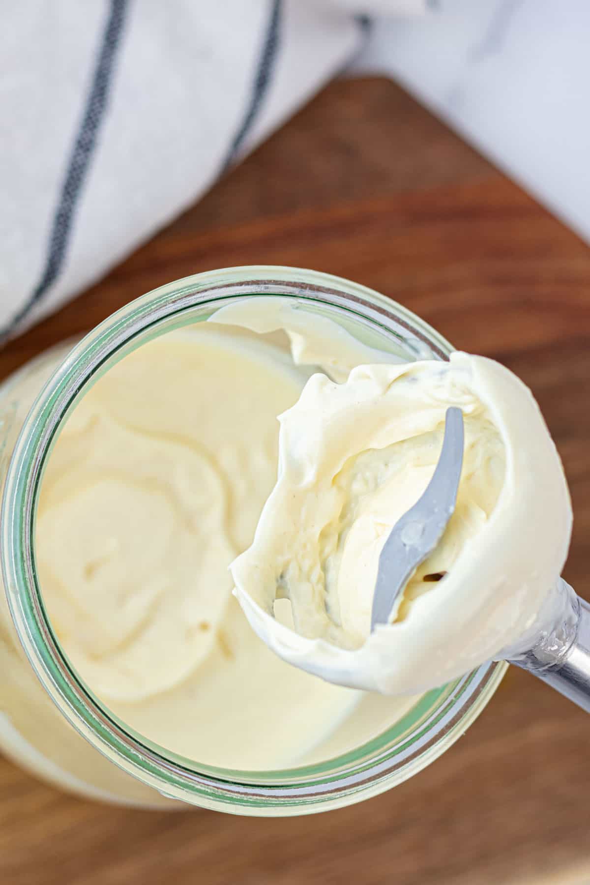 Bottom of the immersion blender coated in a rich and creamy homemade mayonnaise.