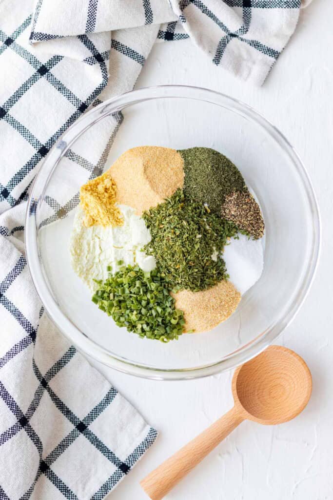 All of the ingredients piled in a glass mixing bowl with a wooden spoon on the side.