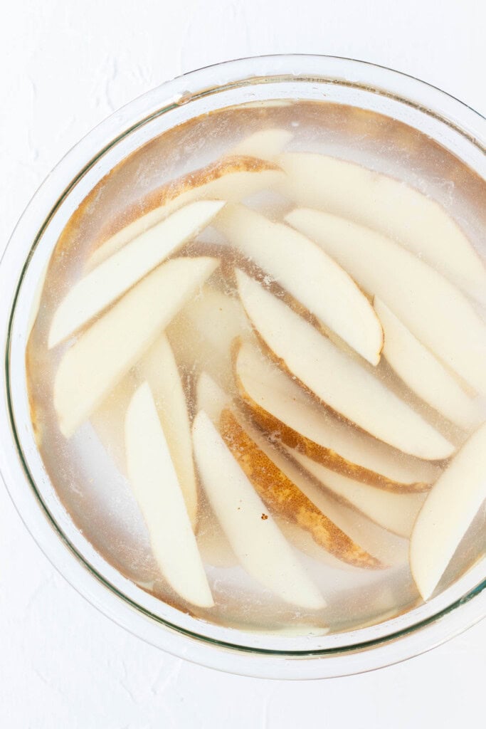 Soaking the potato wedges in a bowl of cold water.