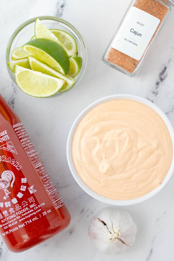A white bowl of spicy mayonnaise with optional addins like Cajun, lime or garlic.