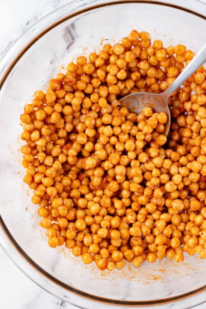 Tossing the chickpeas with the oil, hot sauce and cajun seasoning.