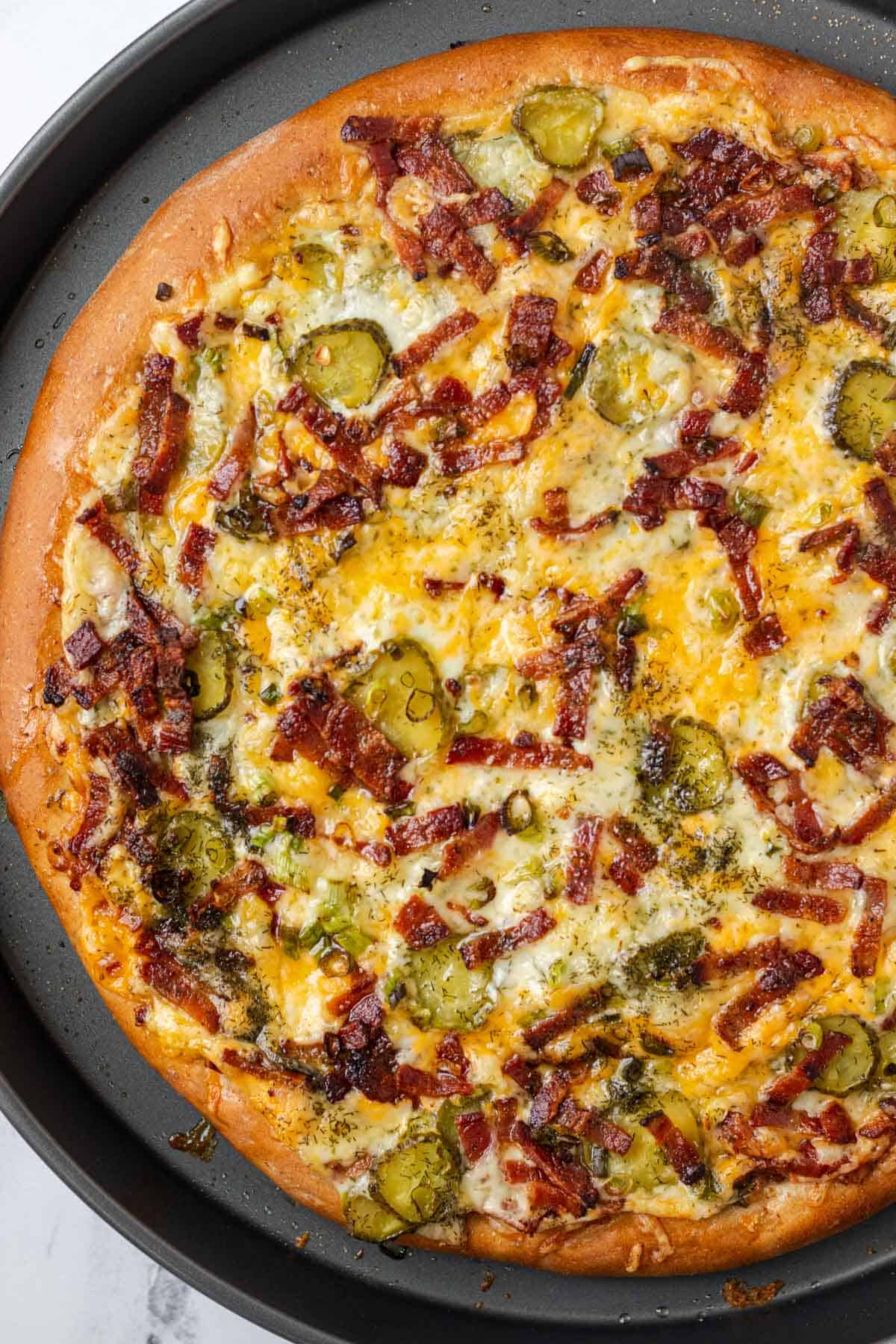 Freshly baked dill pickle pizza golden brown and straight out of the oven.