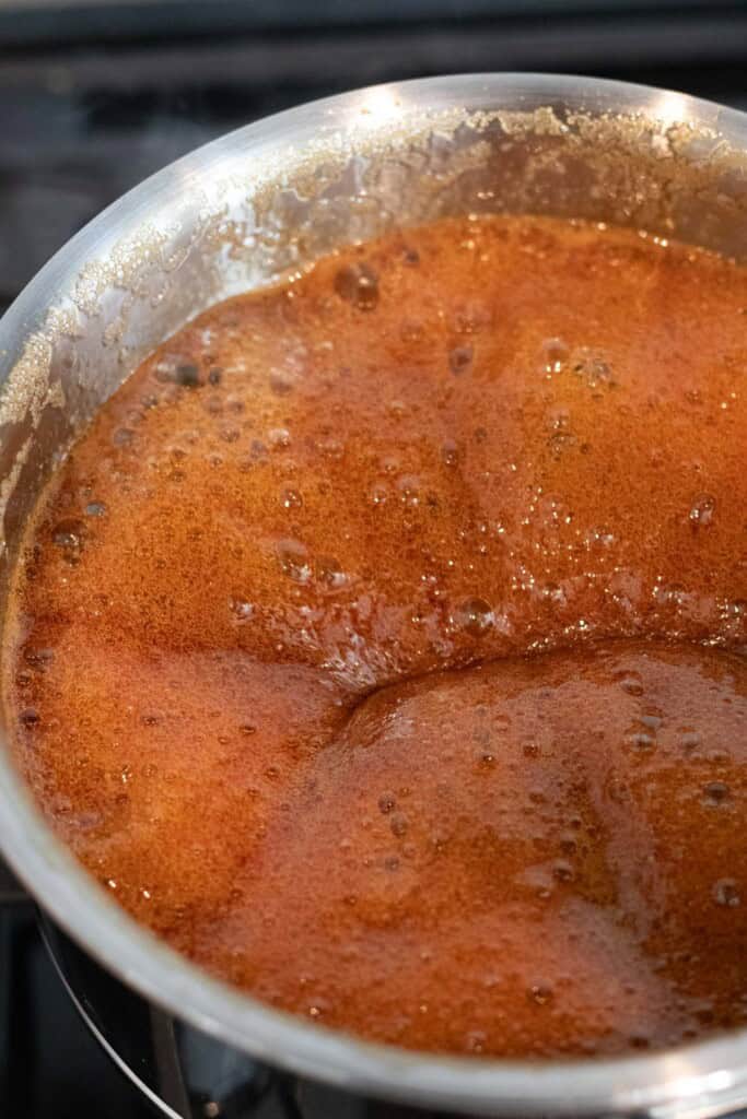 Eel sauce boiling in a saucepan on the stove.