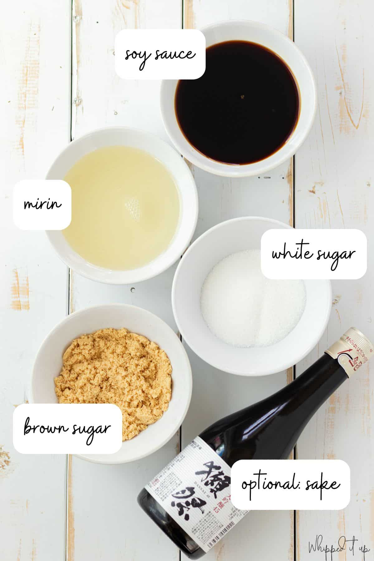 Ingredients for eel sauce measured in white bowls on a wood background.
