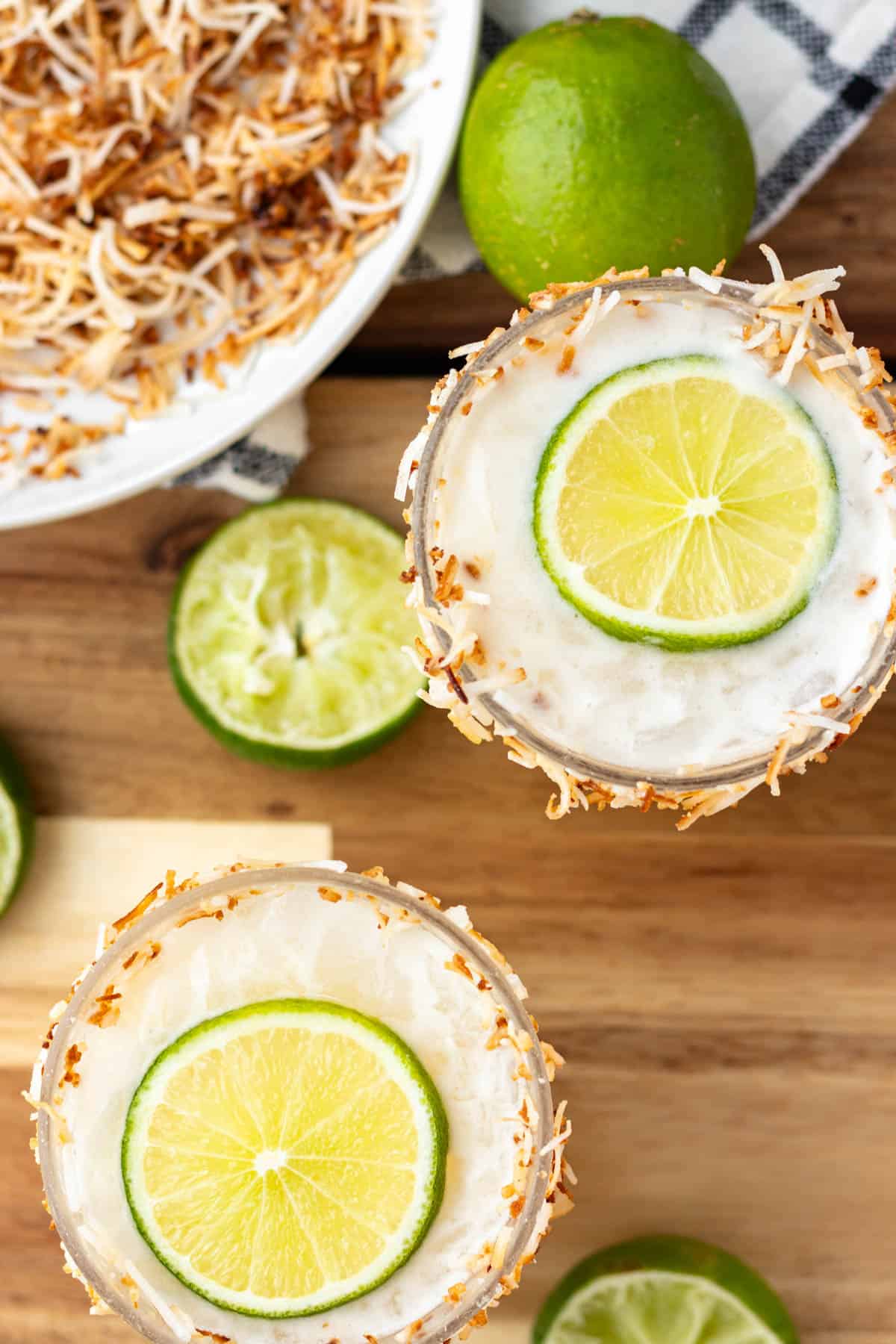 Creamy coconut margarita with a wheel of lime on top.