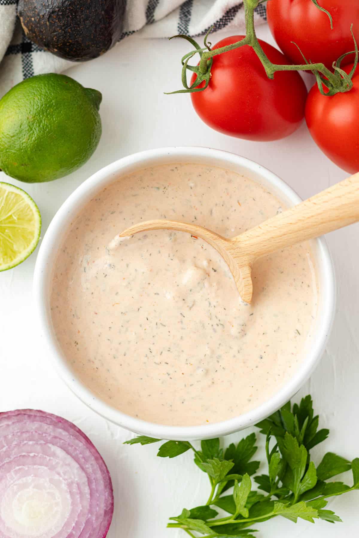 A white bowl full of taco salad dressing with a spoon.