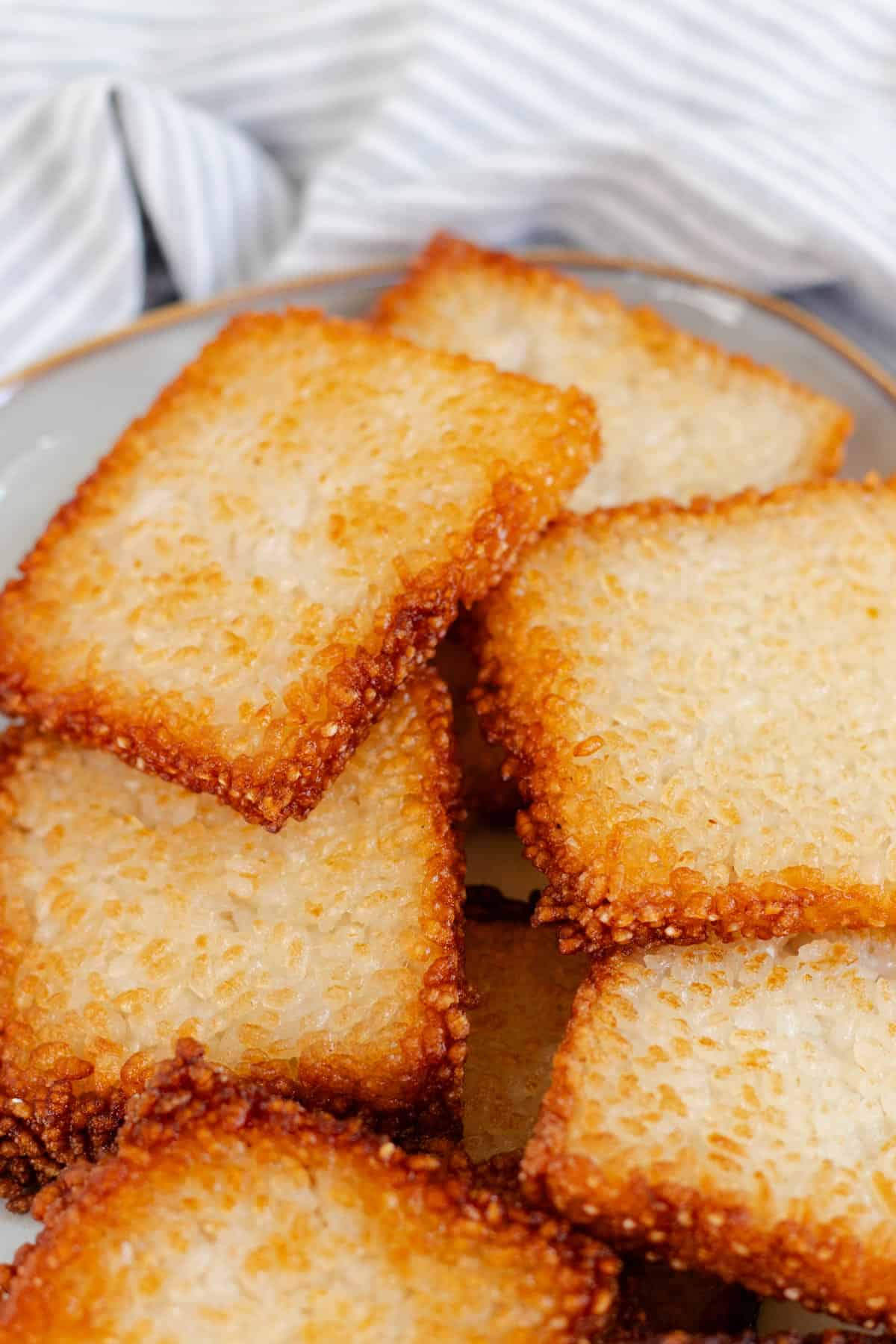 A pile of golden brown crispy rice squares.