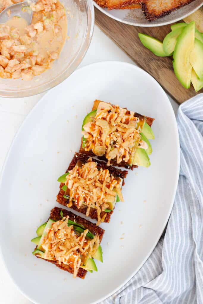 Topping with crispy fried onions, sesame seeds, eel sauce, and spicy mayo drizzle.