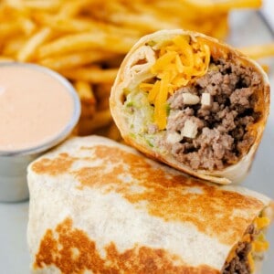Big Mac wrap toasted on a plate with fries and a side of Big Mac sauce.