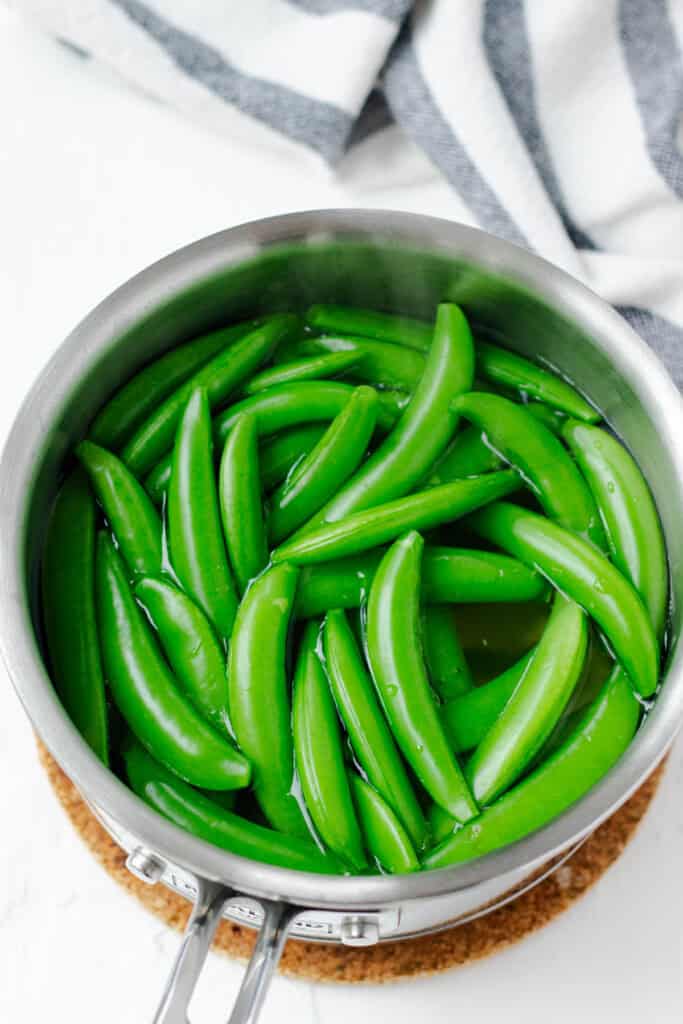 Blanching snow peas in boiling water.