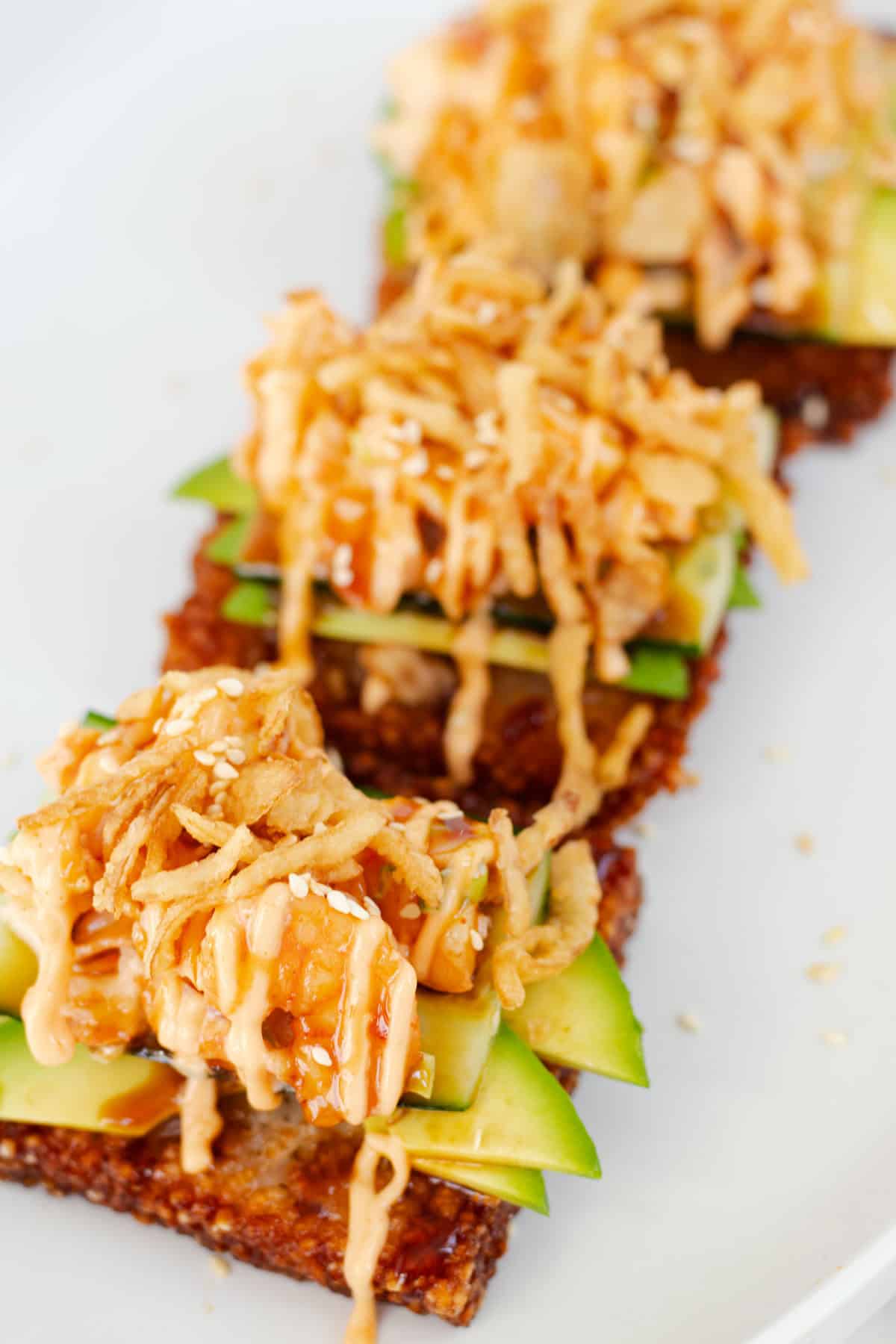 Dynamite crispy rice squares topped with avocado, crispy fried onions, spicy mayo, eel sauce, and shrimp.