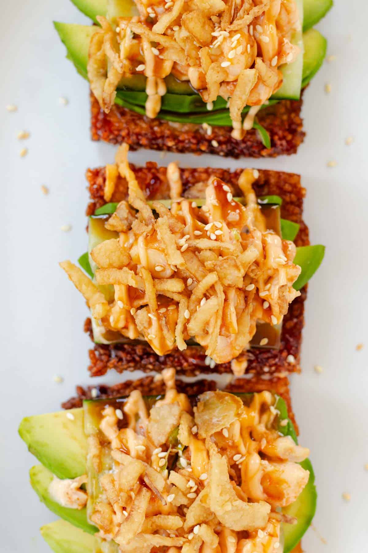 Three dynamite shrimp crispy rice squares layered with avocado and topped with crispy onions, eel sauce, and spicy mayo.