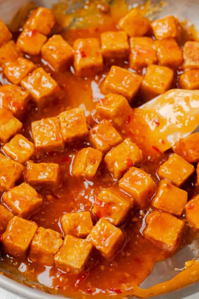 Tossing the crispy baked tofu with the prepared sweet chili sauce.