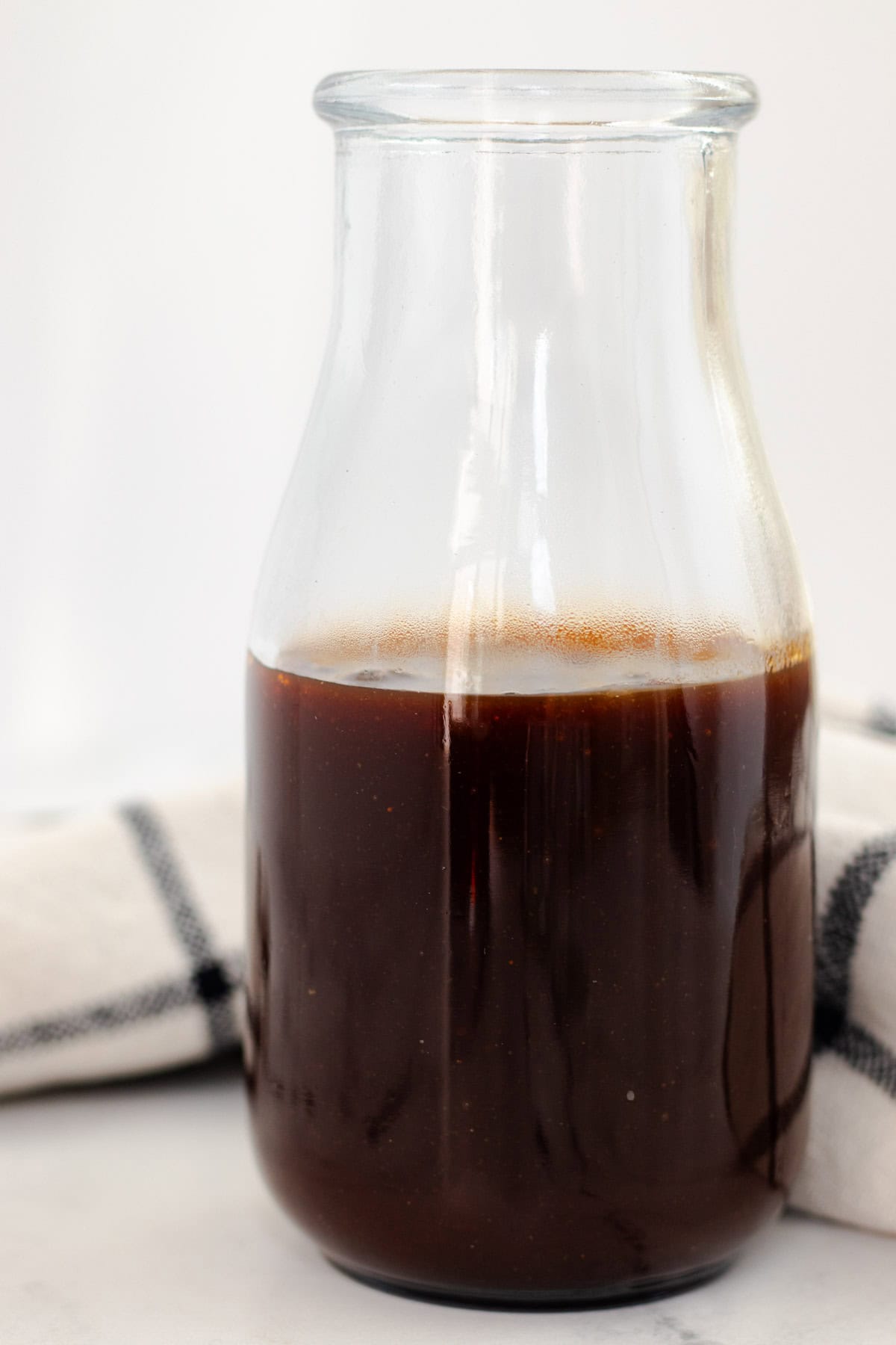 Homemade brown barbecue sauce in a glass bottle.