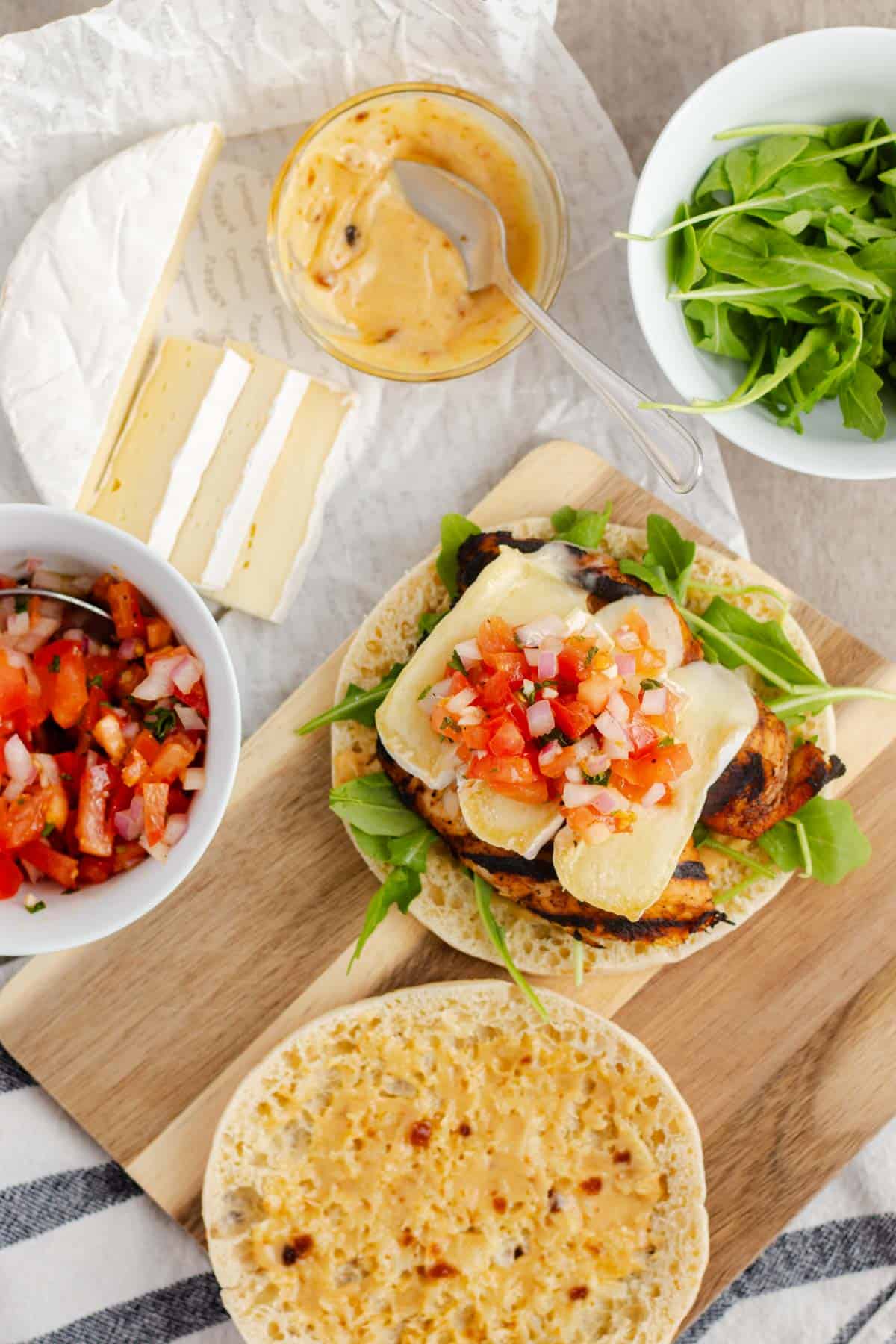 Adding the tomato bruschetta on top of the melty brie on the sandwich.