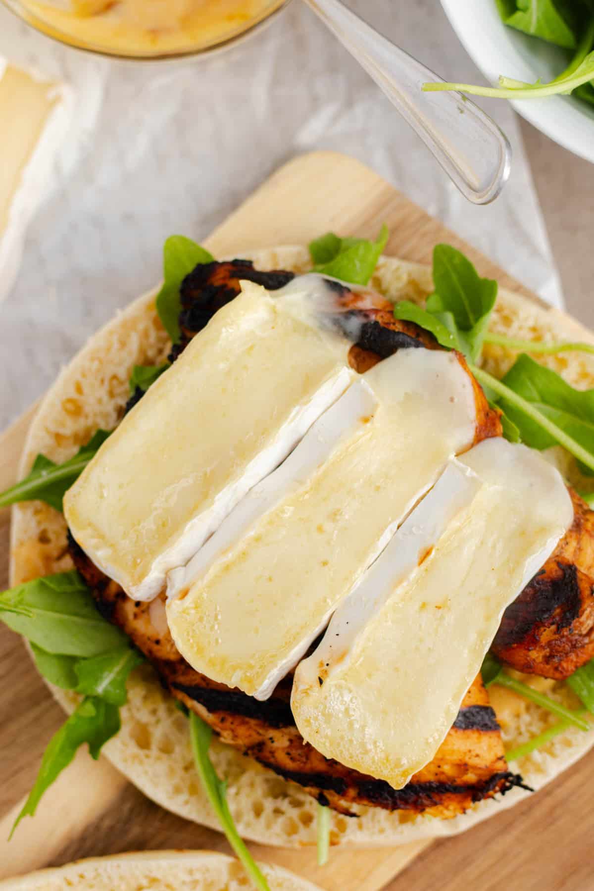 Melty brie cheese on top of a grilled chicken breast.