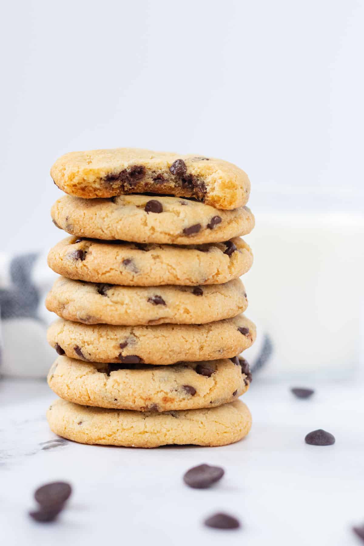 A stack of 7 cookies, with a bite out of the top one to show how chewy and soft they are.