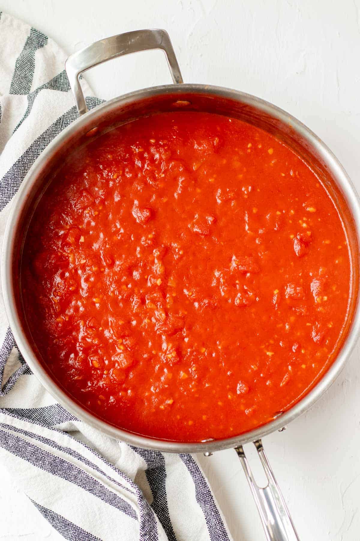Preparing the vodka and tomato base of the sauce in a large, deep skillet.