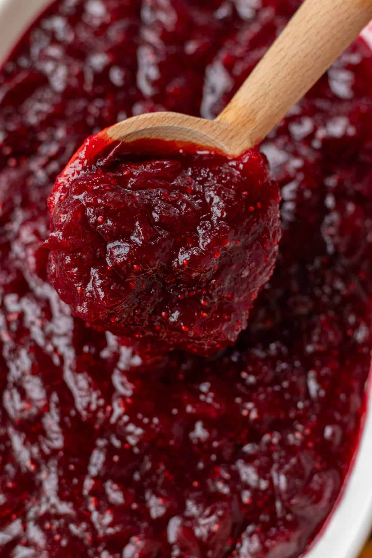 A wooden spoonful of cranberry sauce.