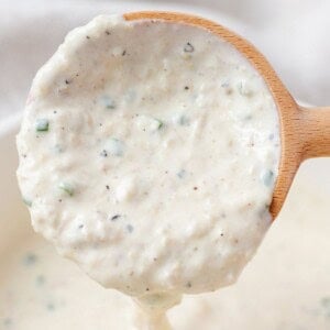 Horseradish sauce running off of a wooden spoon.