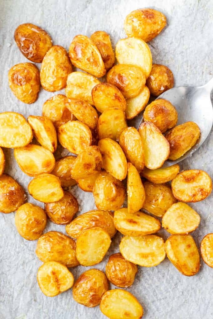 Tossing roasted potatoes with flaky sea salt.