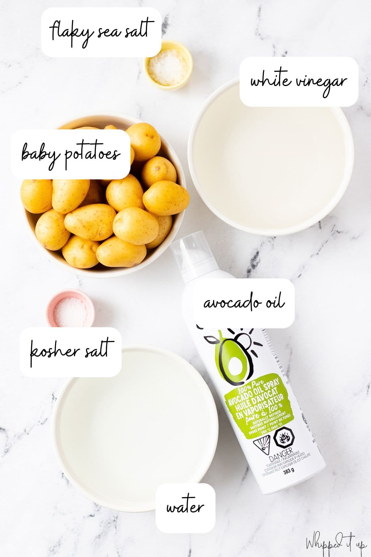 Ingredients measured out in white bowls on a marble background.