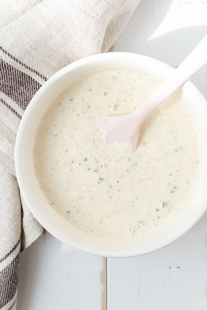 Stirring together the sauce in a white bowl.